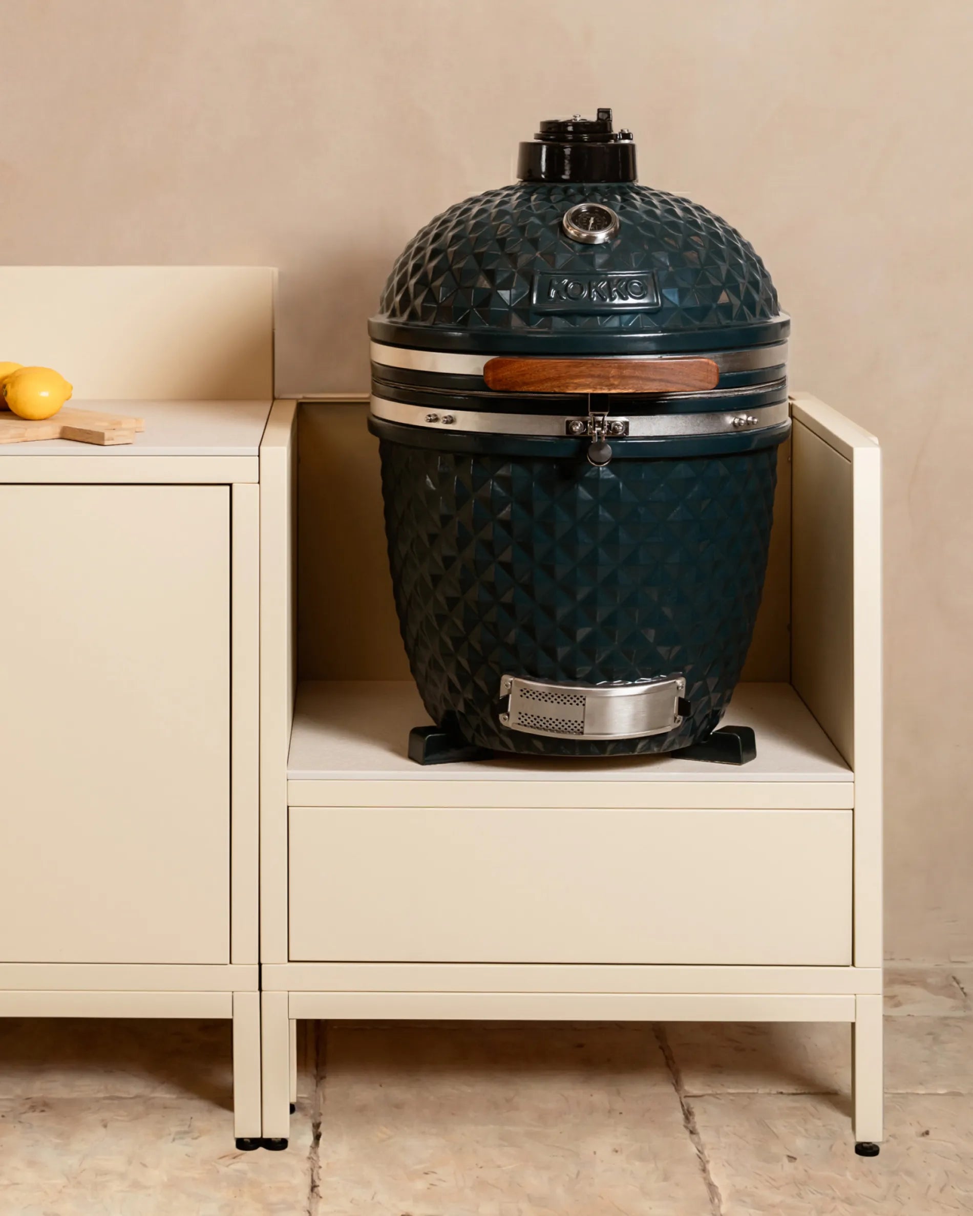 Barbecue kamado bleu marine Kokko installé dans caisson beige crème PILOTIS, cuisine extérieure