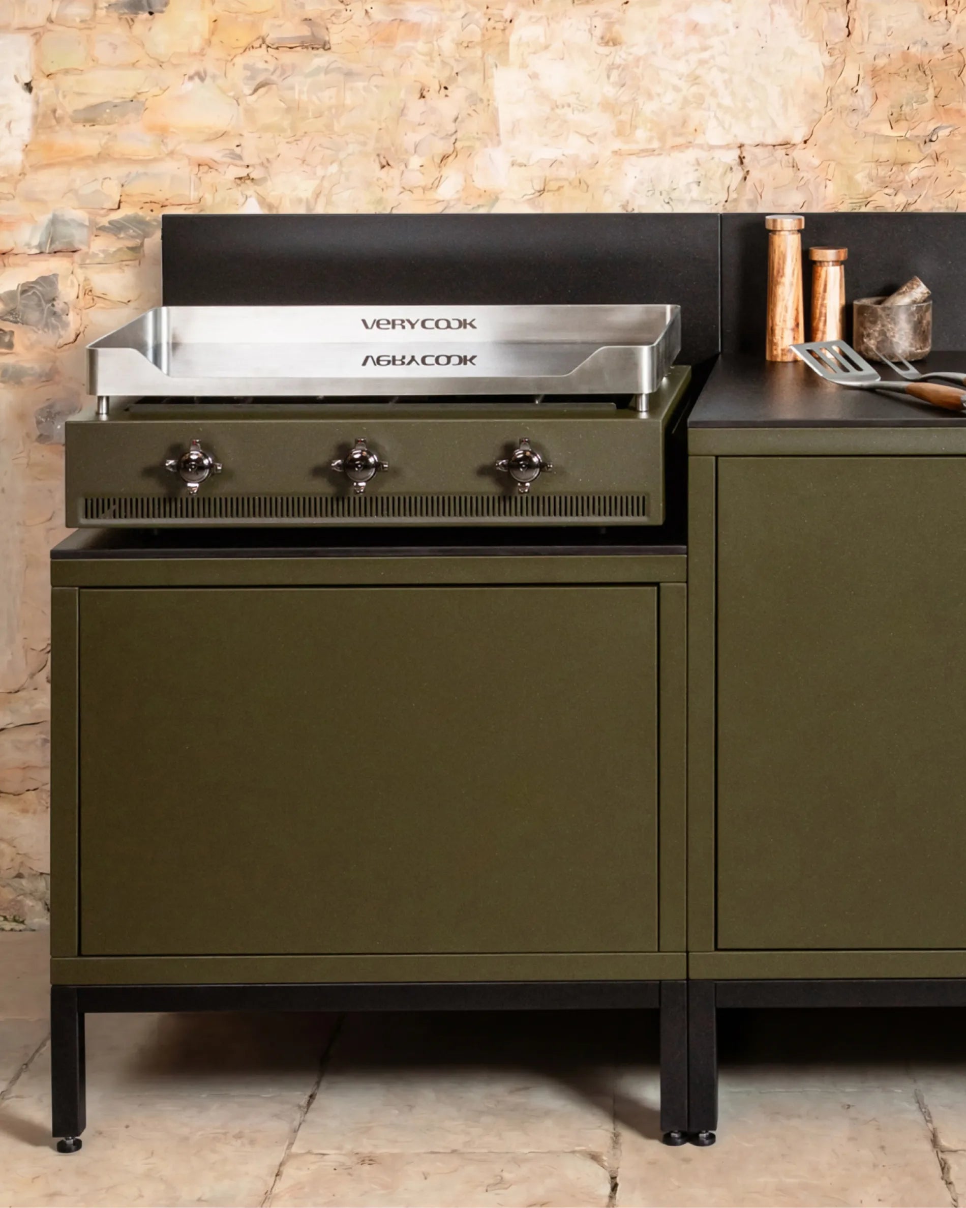 Plancha Verycook geplaatst op een olijfgroene PILOTIS-module, buitenkeuken met koperen accessoires