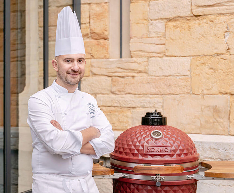 Chef aan het koken op een rode Kokko kamado tijdens professioneel gebruik.