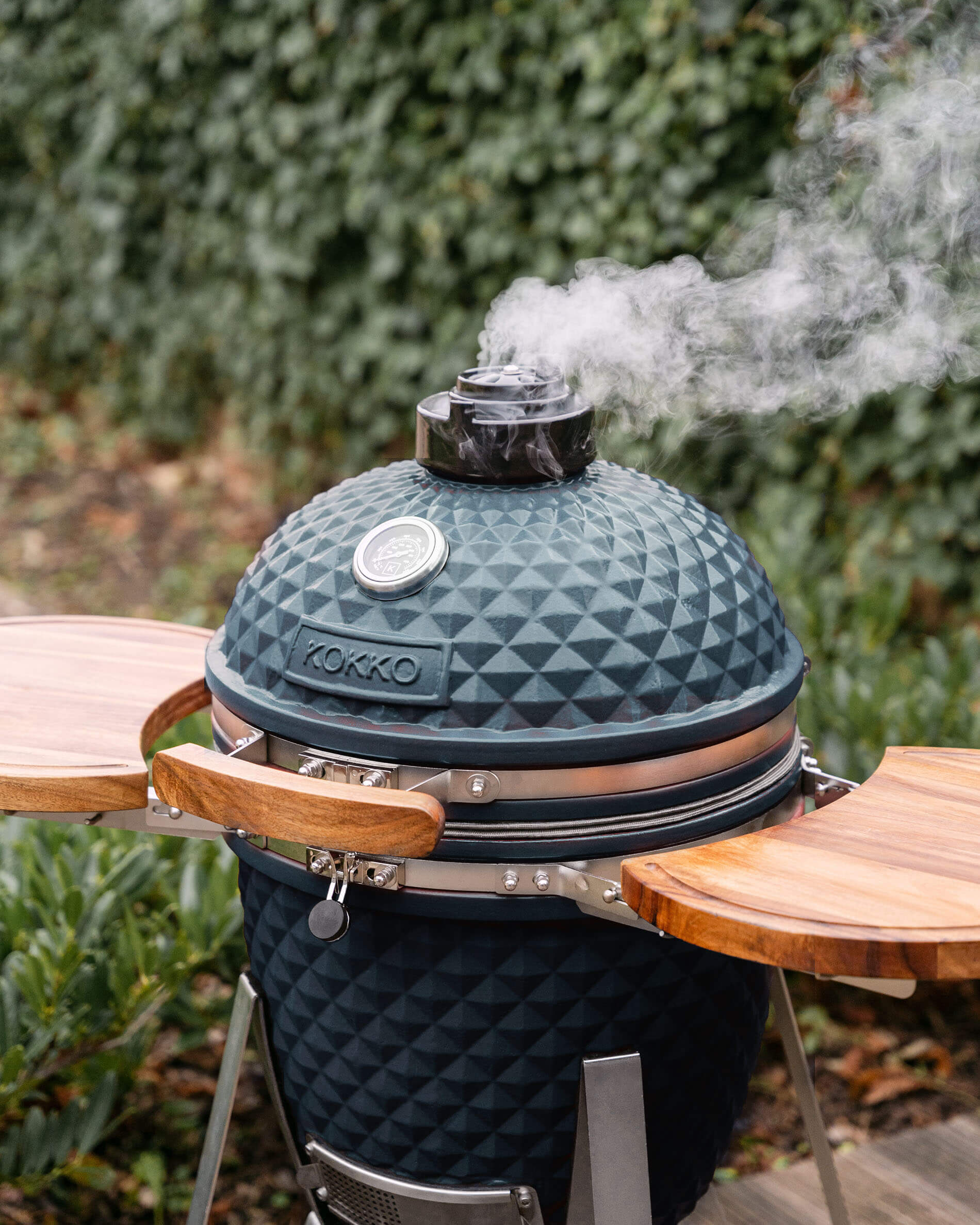Kamado Kokko L 18 inch keramisch in oceaanblauw, geplaatst buiten.