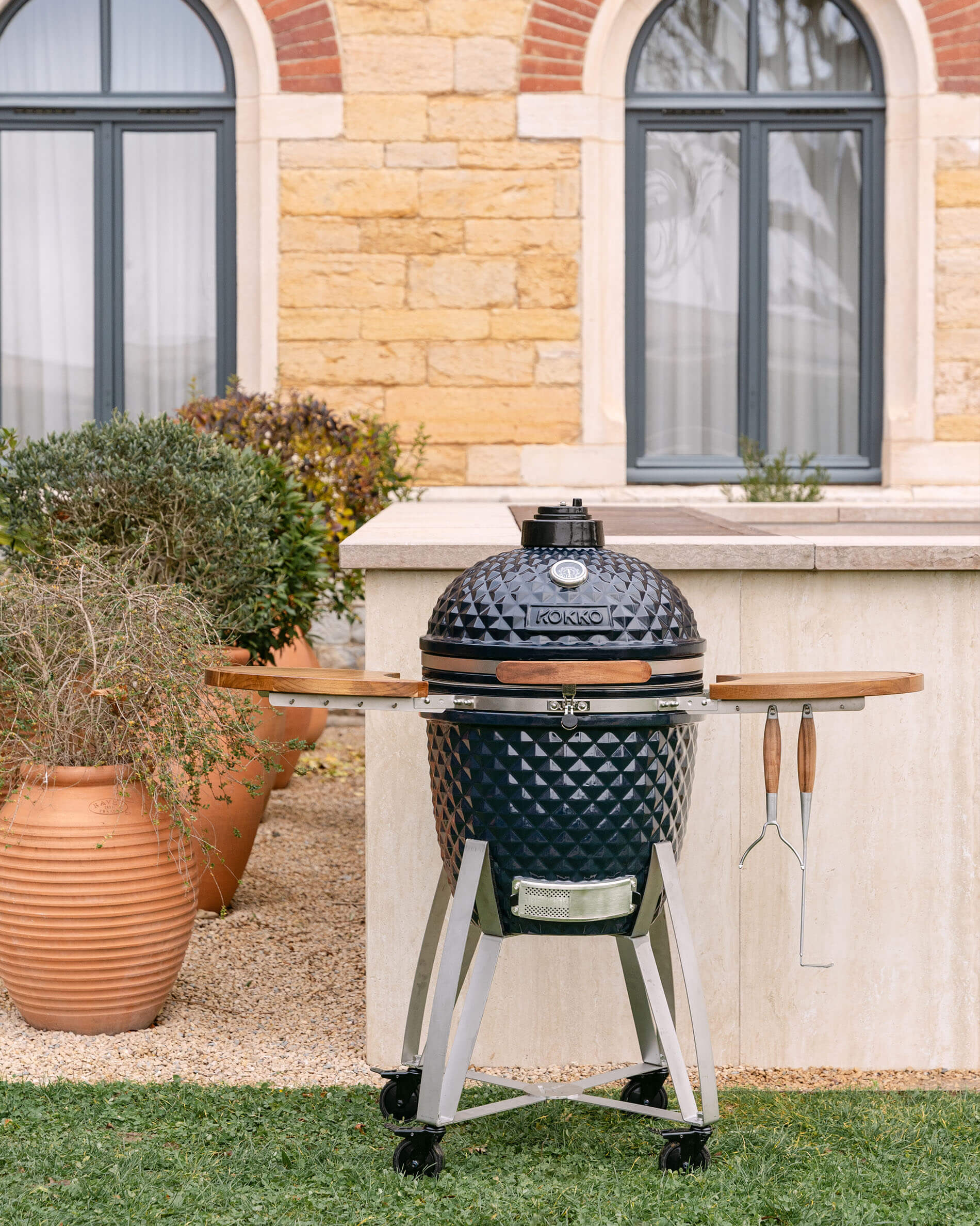 Kamado Kokko XL 22 inch in marineblauw keramiek, gesloten en gepresenteerd op een onderstel.