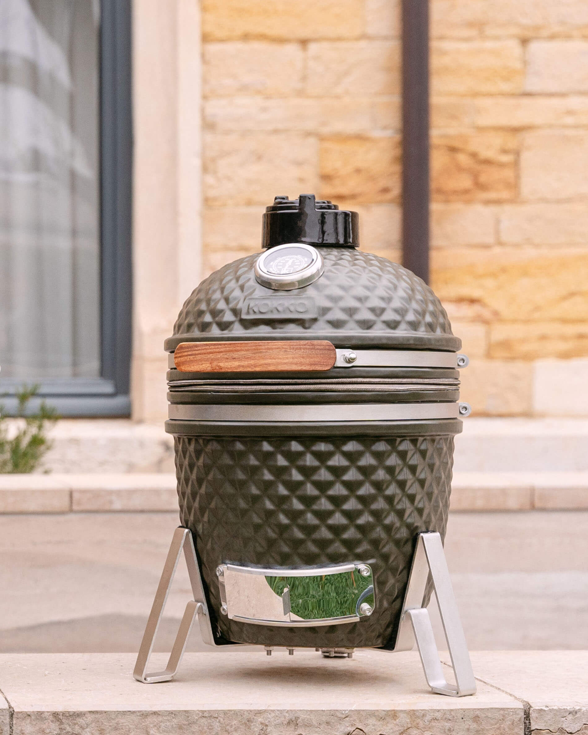 Kamado Little Kokko 13 van olijfgroene keramiek op zijn onderstel.