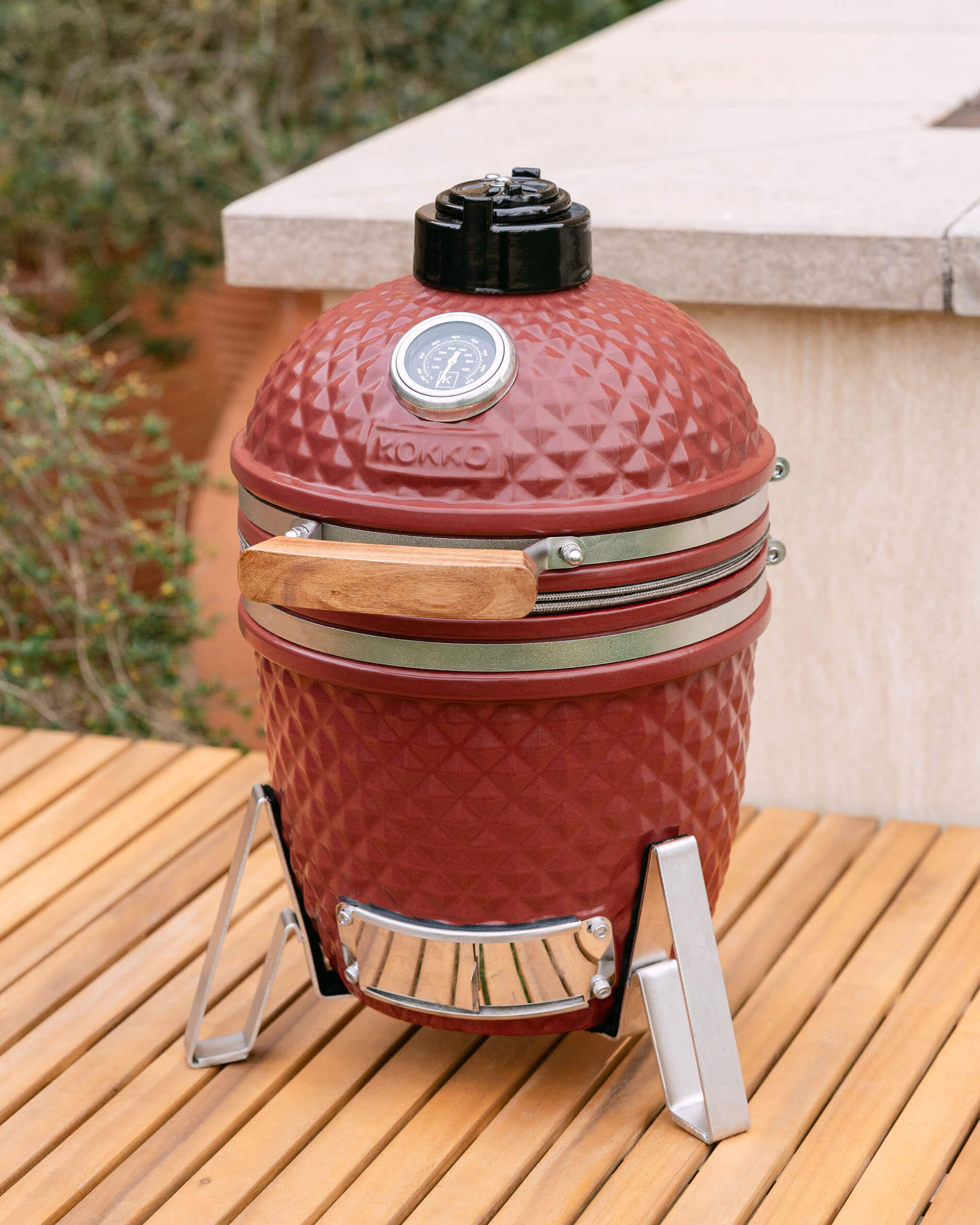 Kamado Little Kokko 13 rood oxide geplaatst op een terras.