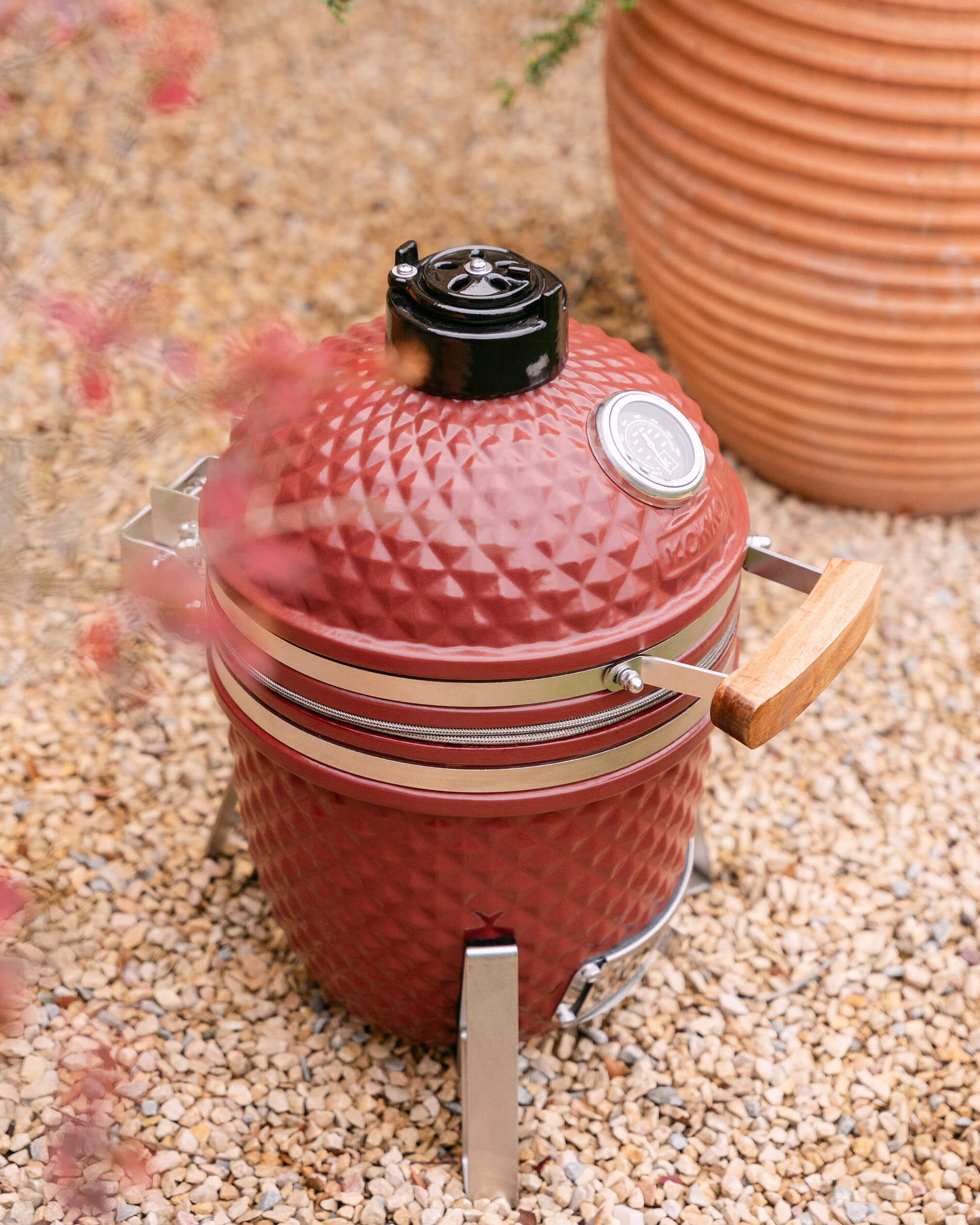 Kamado Little Kokko 13 in rood oxide keramiek, frontaal gezien.