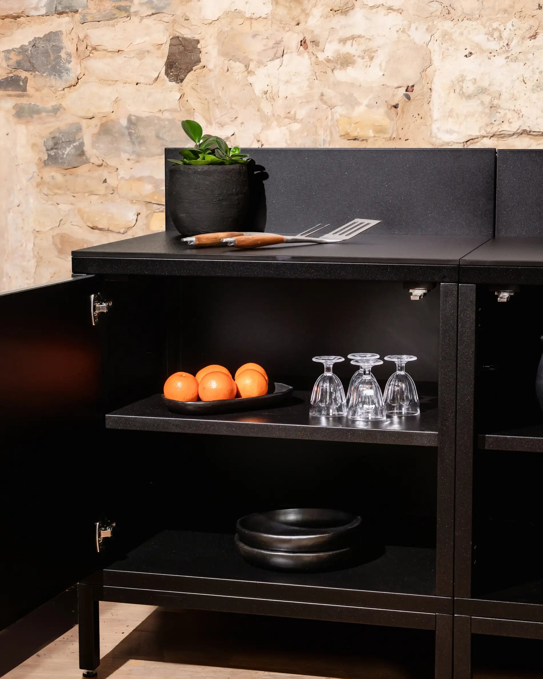 Module de rangement Kokko noir avec étagères ouvertes et accessoires de cuisine