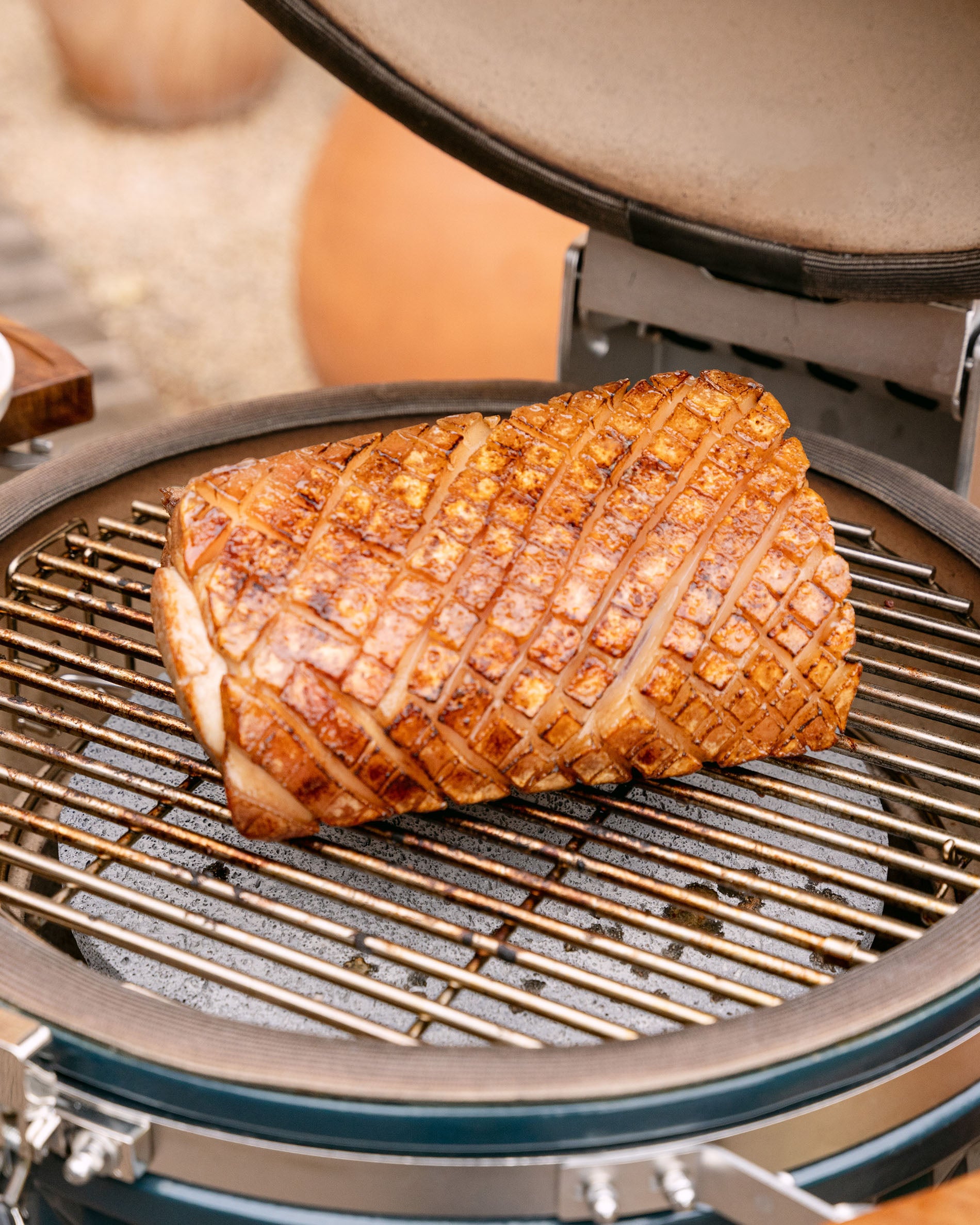 Gaarproces van een varkensgebraad op het rooster van een Kokko kamado, deksel open, met een goudbruine en gelijkmatige korst.