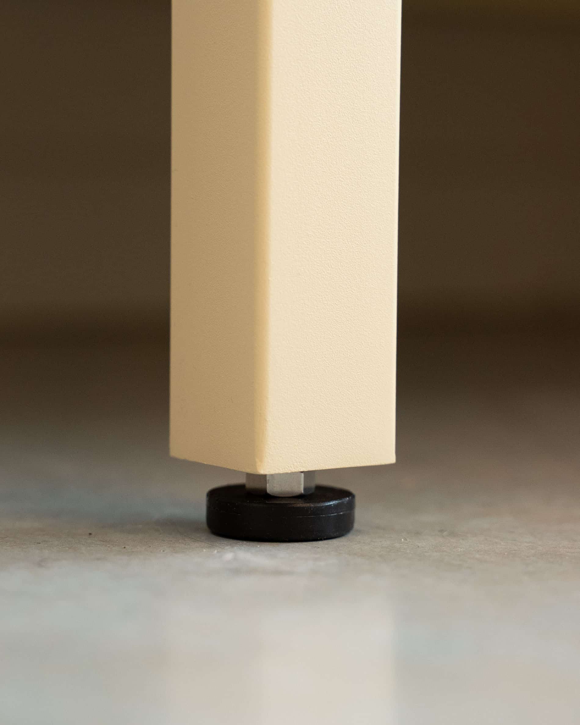 Detail van de verstelbare poot van een pilotis buitenkeuken, met de verhoogde structuur en het nivelleersysteem van het meubel.