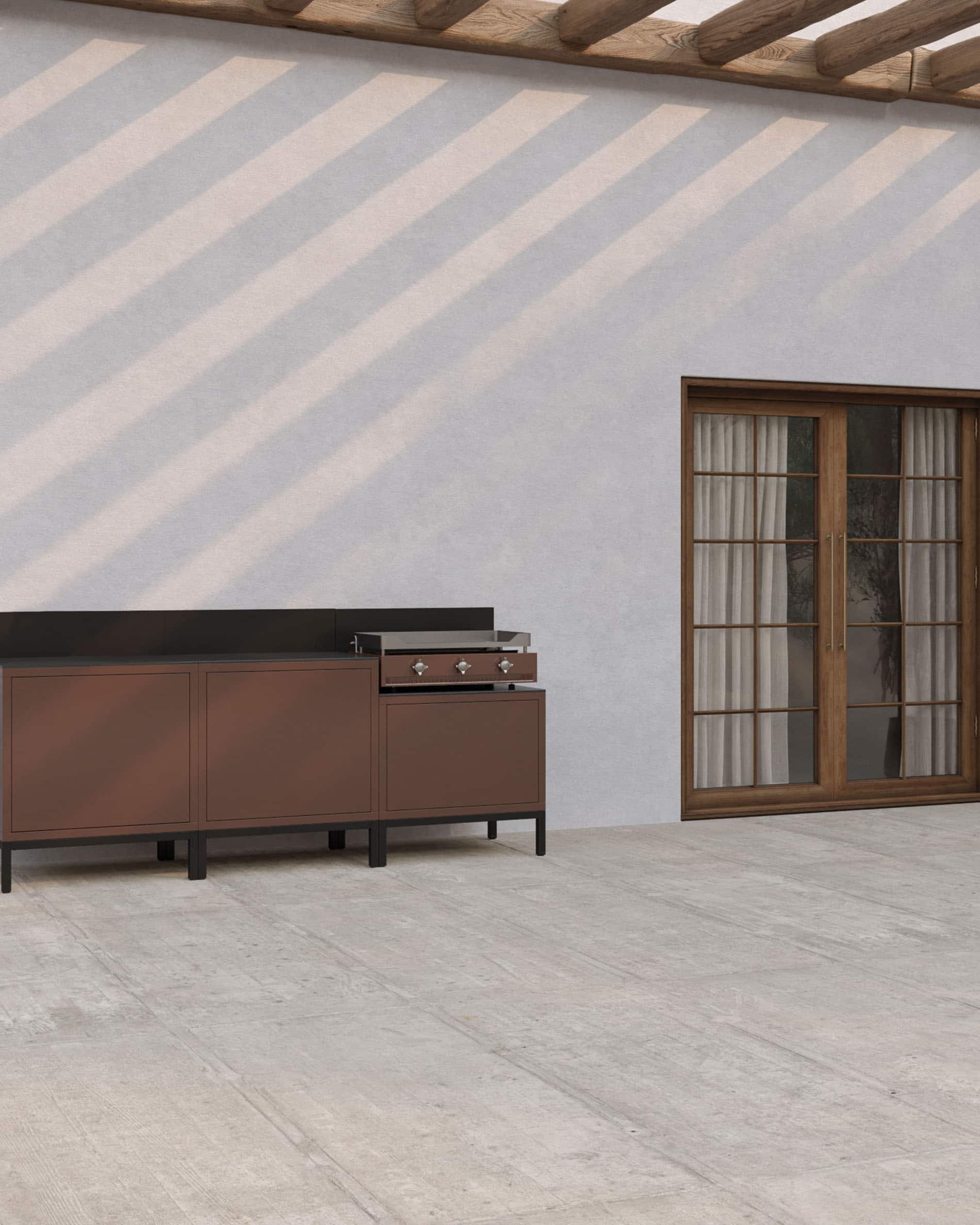 Buitenkeuken op palen met geïntegreerde plancha, meubels in roestbruine kleur, gesloten opbergruimtes en donker werkblad, geplaatst op een overdekt terras.